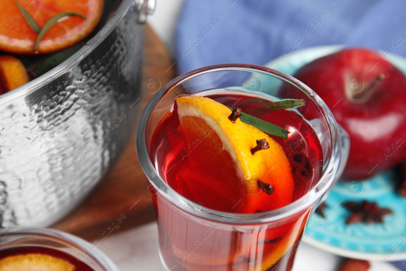 Photo of Tasty mulled wine with spices on table, closeup