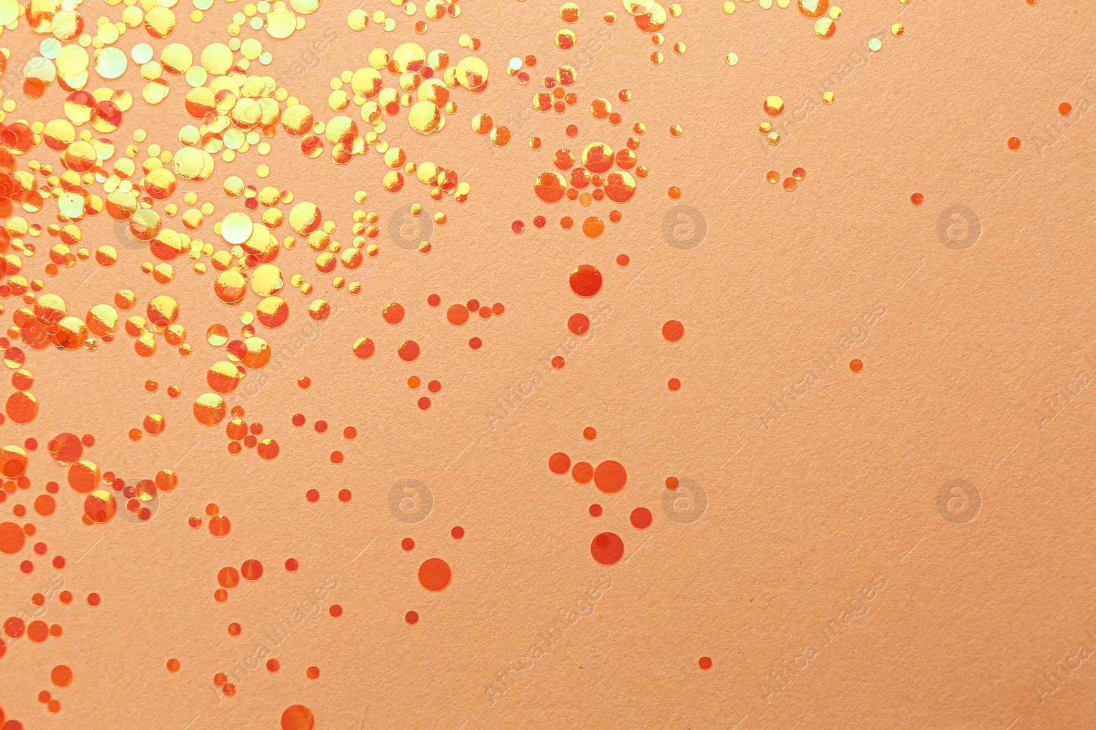 Photo of Shiny bright orange glitter on beige background, flat lay. Space for text