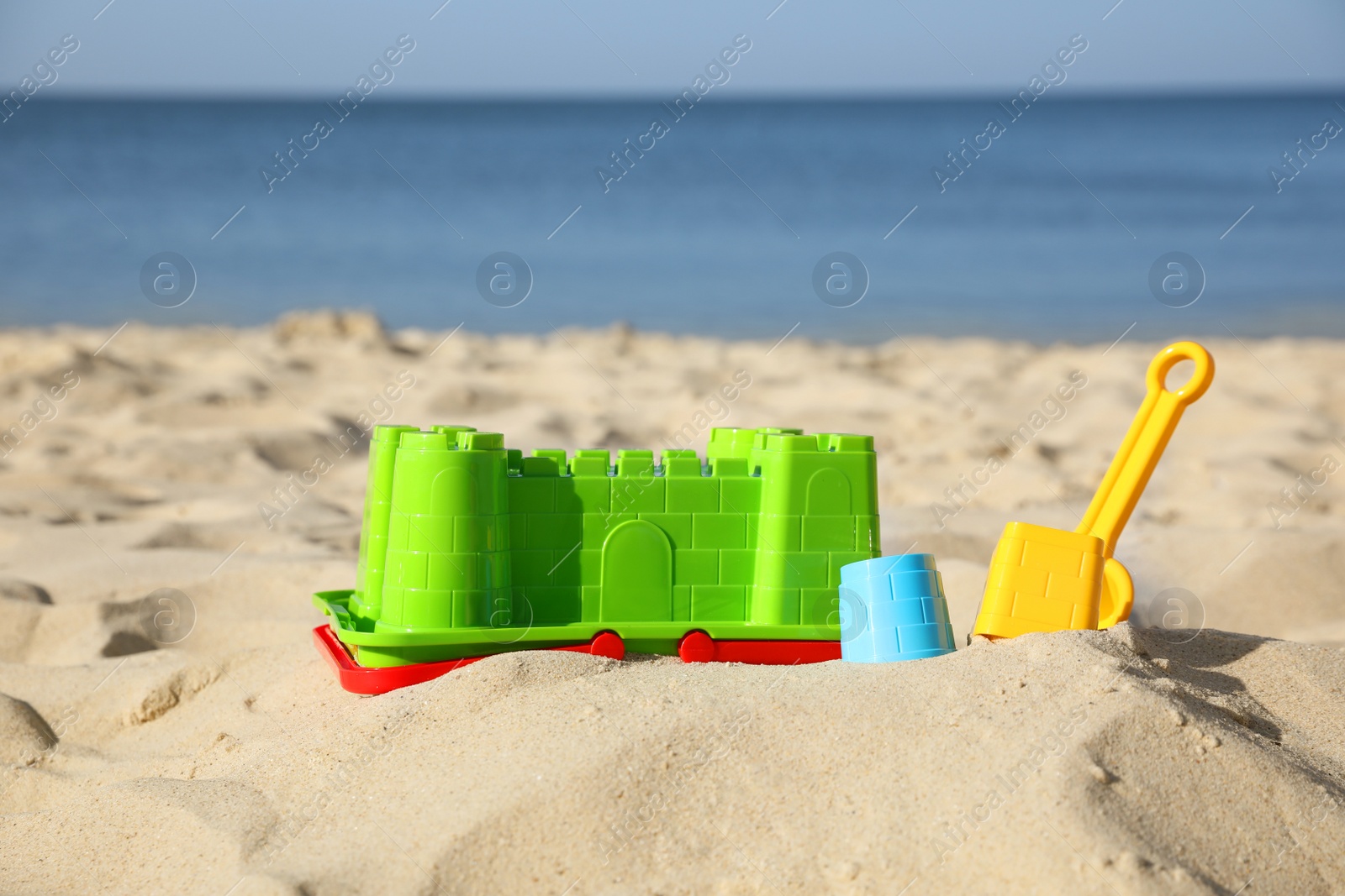 Photo of Bright child plastic toys on sandy beach