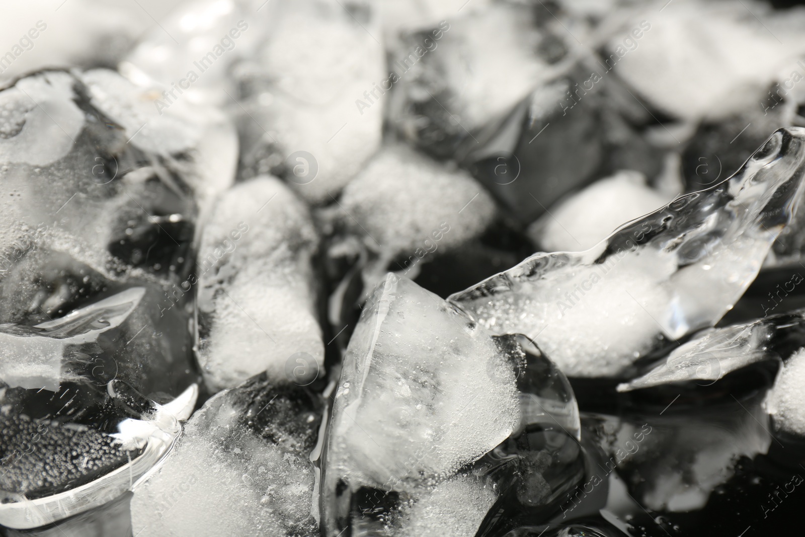 Photo of Pieces of crushed ice on mirror surface, closeup