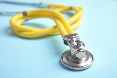 Photo of Stethoscope with space for text on color background, closeup. Medical tool