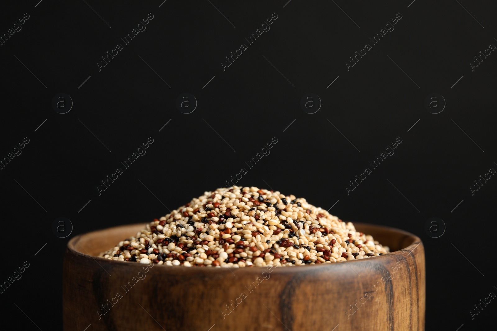 Photo of Bowl with mixed quinoa seeds on black background, closeup. space for text