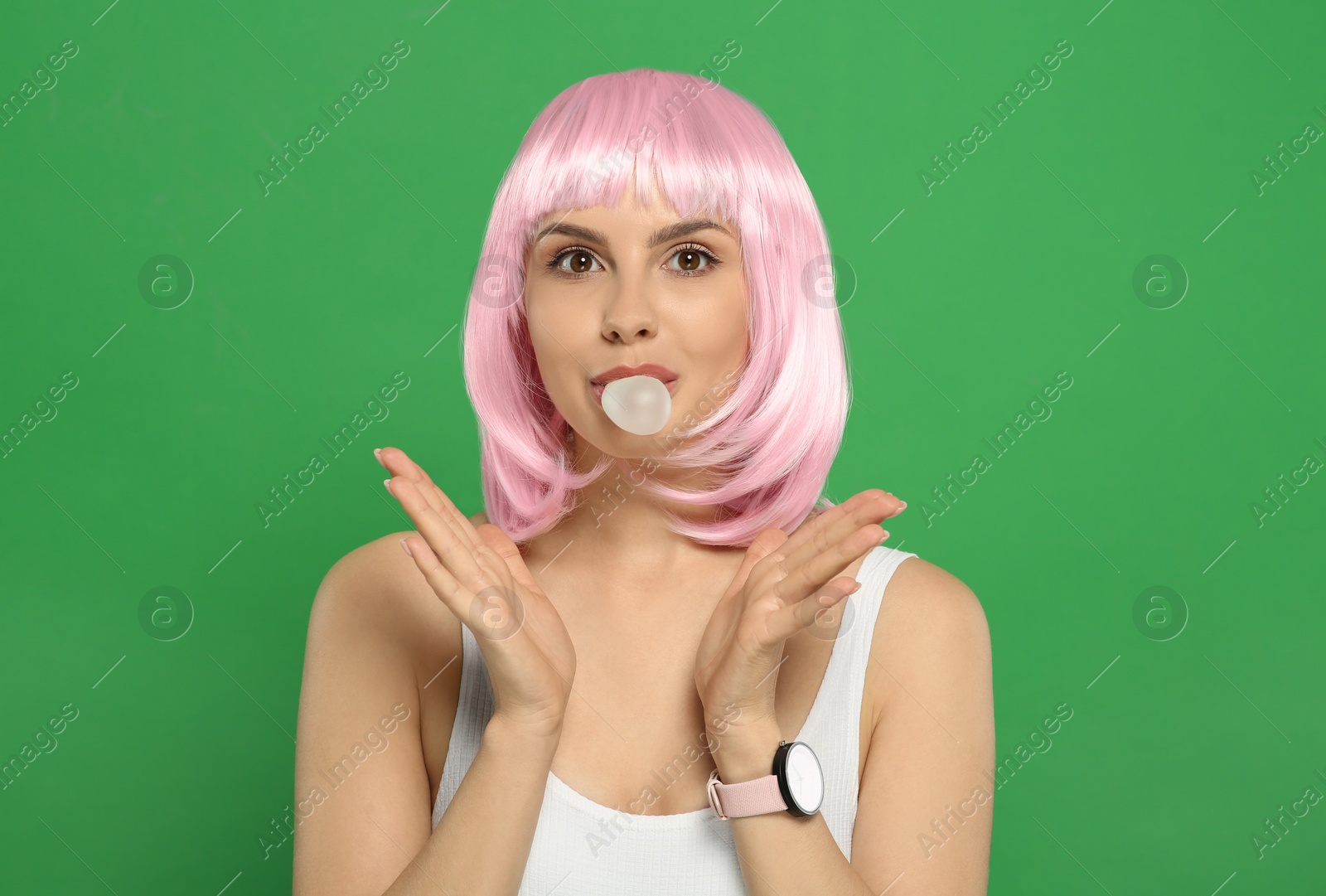 Photo of Beautiful woman blowing bubble gum on green background