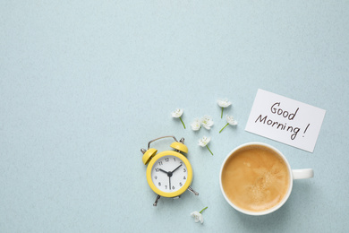 Photo of Flat lay composition with message GOOD MORNING and coffee on light blue background. Space for text