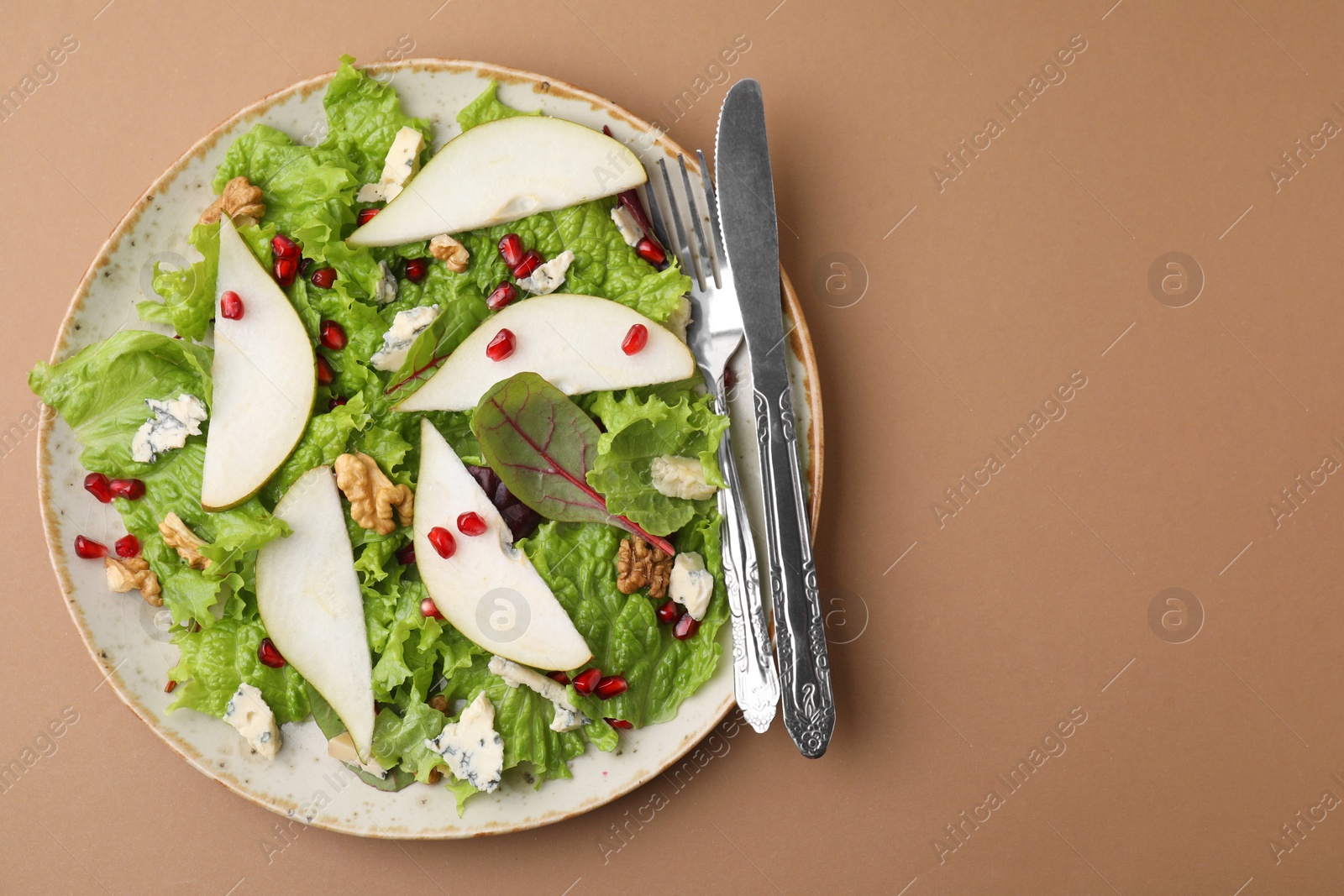 Photo of Delicious pear salad and cutlery on beige background, top view. Space for text