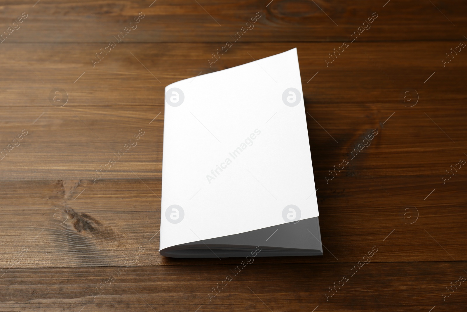 Photo of Blank paper brochure on wooden table. Mockup for design