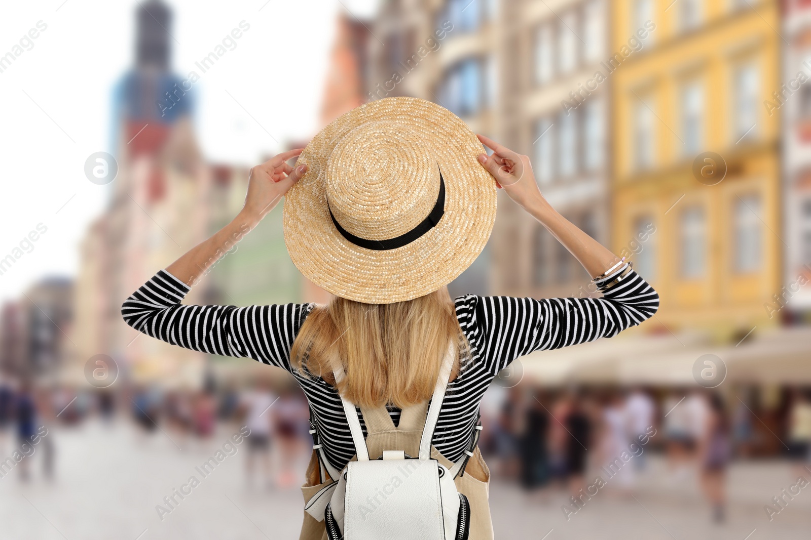 Image of Traveler with backpack in foreign city during summer vacation, back view