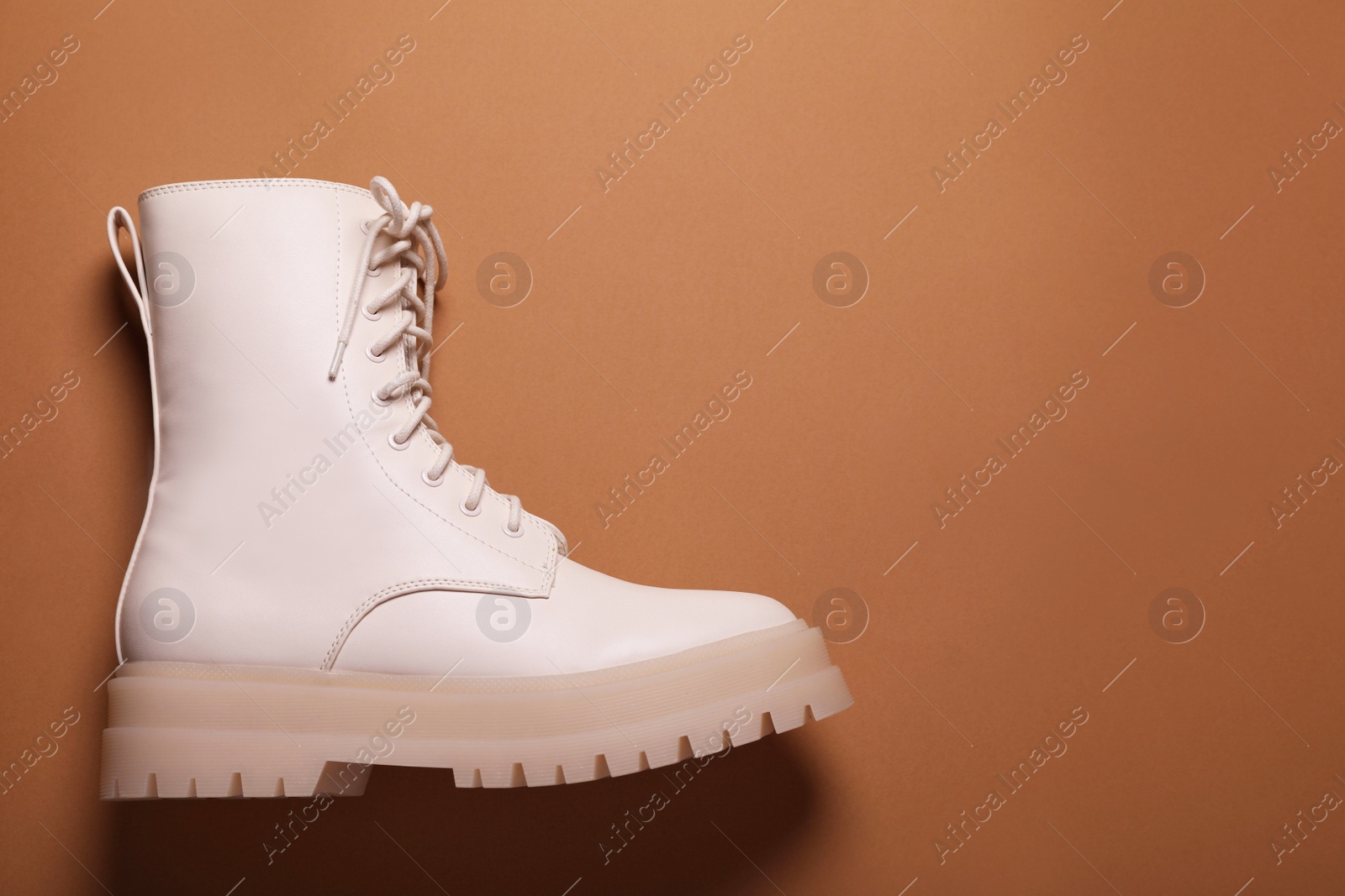 Photo of Stylish leather shoe on light brown background, top view. Space for text