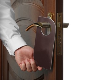 Photo of Man putting blank hanger on hotel door handle against white background, closeup