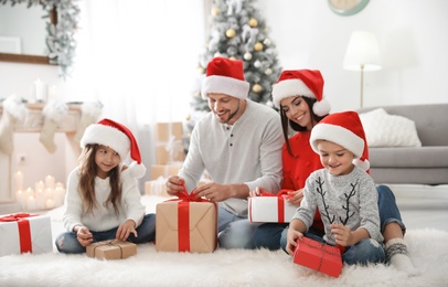 Photo of Happy family with children and Christmas gifts on floor at home