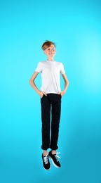 Photo of Portrait of young boy jumping on color background