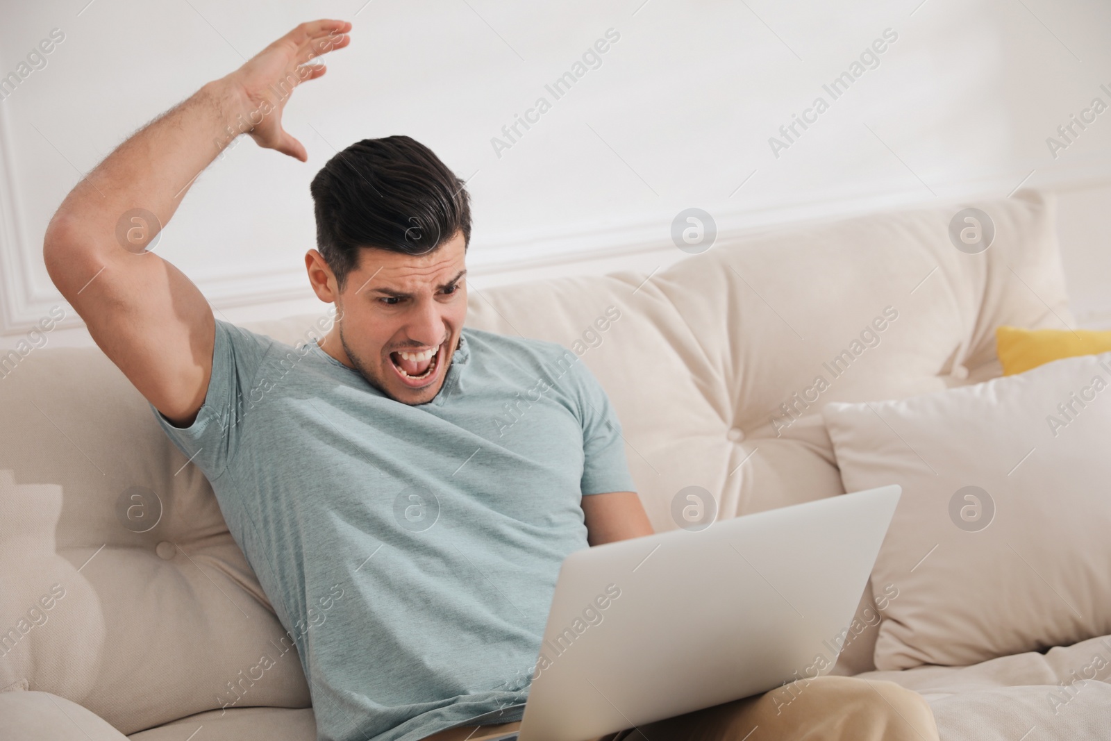 Photo of Emotional man working with laptop at home