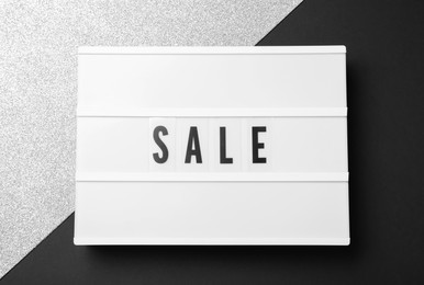 Photo of Lightbox with word Sale on color background, top view. Black Friday