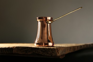 Photo of Beautiful copper turkish coffee pot on wooden table