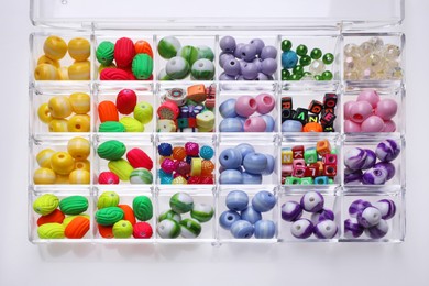 Photo of Plastic organizer with different beads on white background