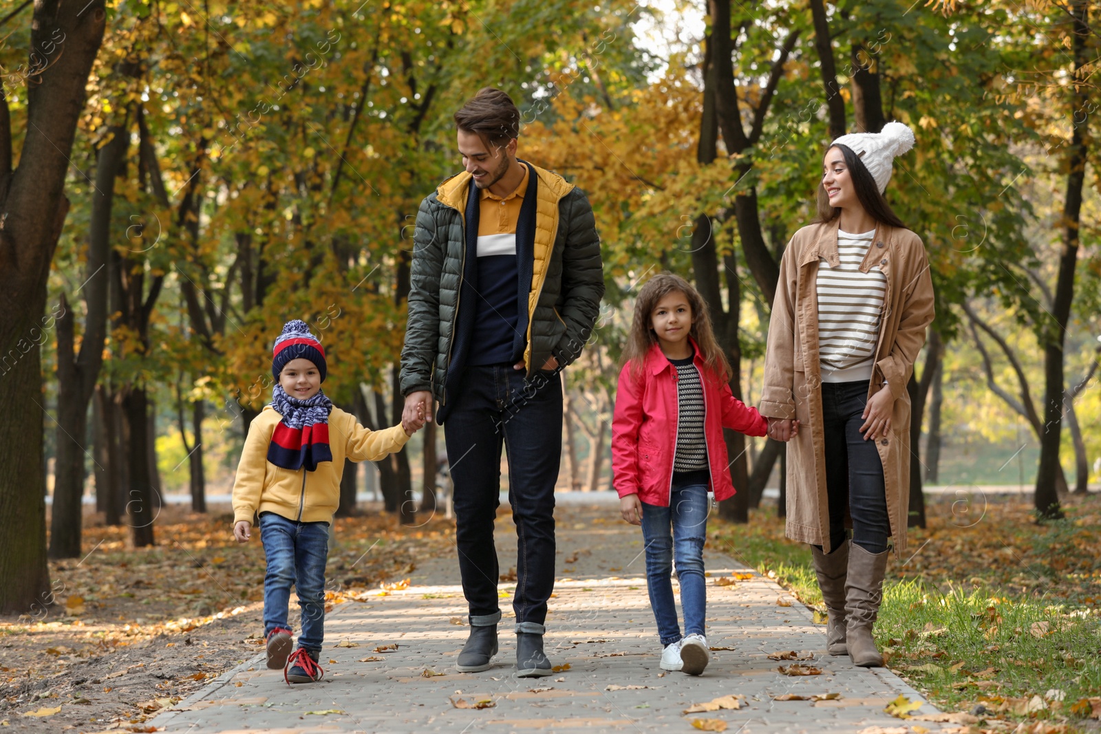 Photo of Happy family with children spending time together in park. Autumn walk