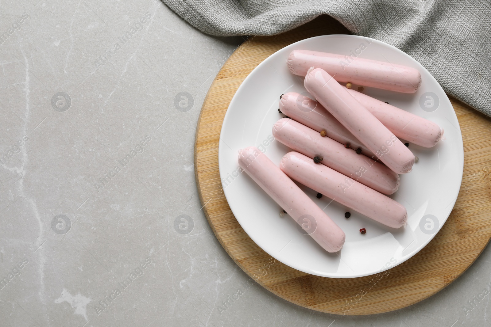 Photo of Vegan sausages with spices on light grey marble table, top view. Space for text