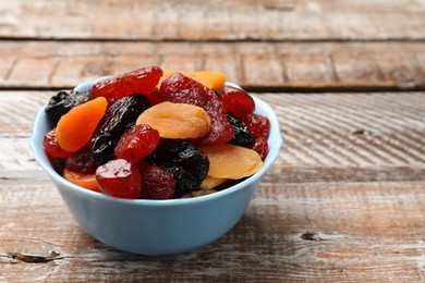 Mix of delicious dried fruits on wooden table, closeup. Space for text