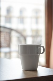 Ceramic cup on wooden table indoors, space for text. Good morning