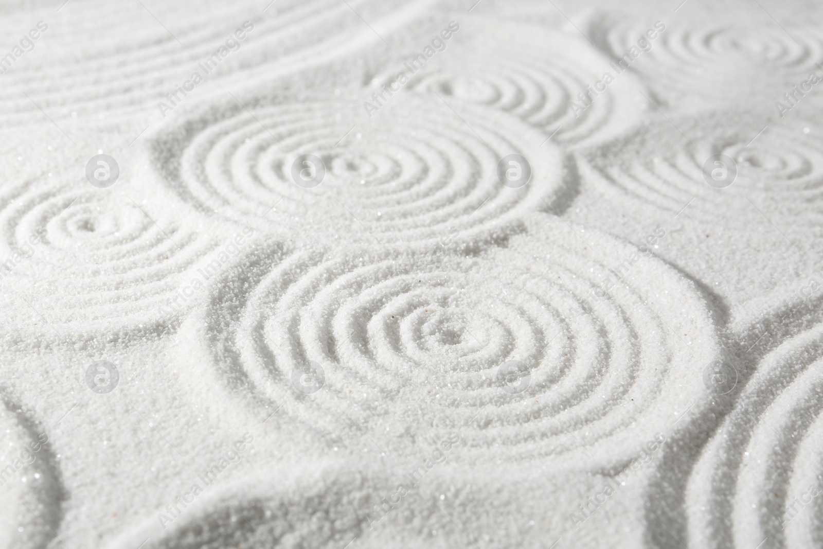 Photo of Zen rock garden. Circle patterns on white sand, closeup