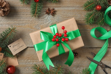 Photo of Flat lay composition with Christmas gift box and fir tree branches on wooden table