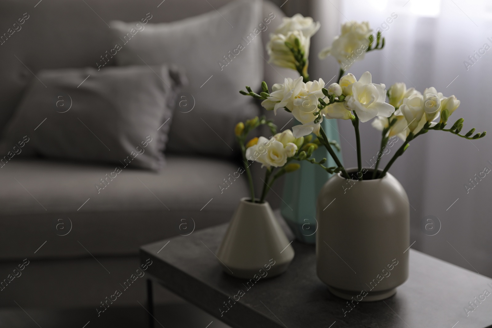 Photo of Beautiful spring freesia flowers on table in room