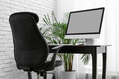 Photo of Stylish workplace interior with modern office chair