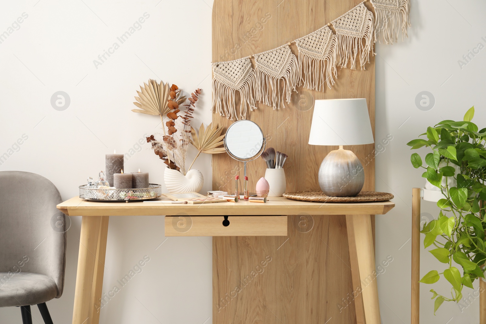 Photo of Dressing table with mirror, makeup products and decor in room