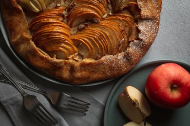 Photo of Delicious galette with apples served on light grey textured table, flat lay