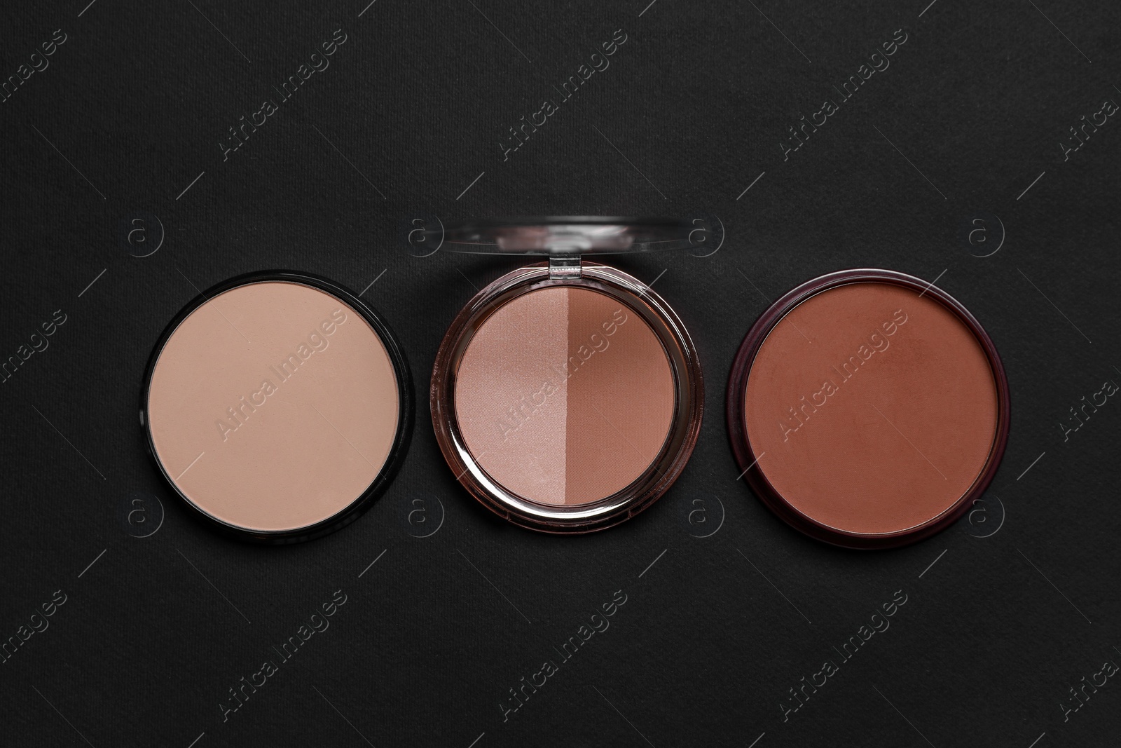 Photo of Different face powders on black background, flat lay