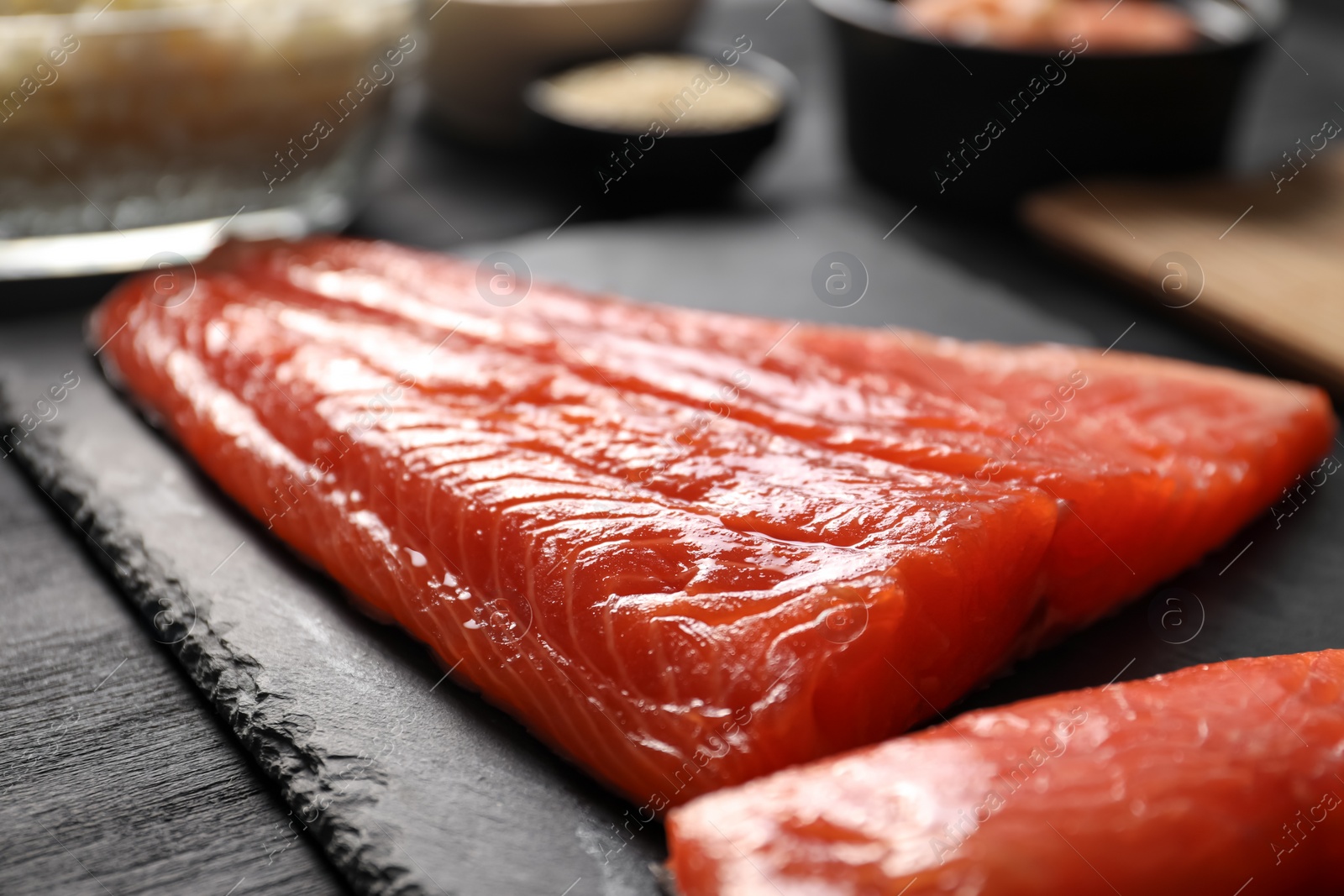 Photo of Fresh salmon for sushi on black wooden table, closeup