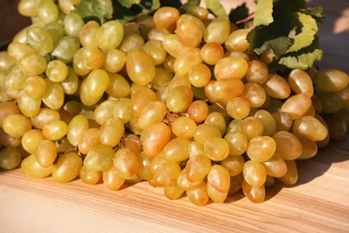 Photo of Fresh ripe juicy grapes on wooden table