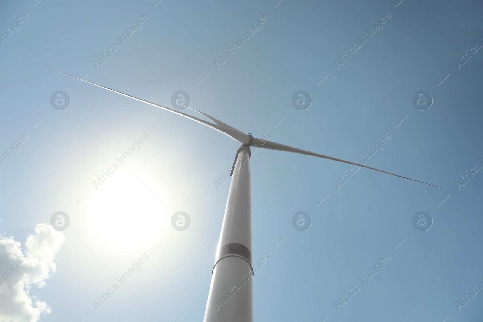 Photo of Modern wind turbine against blue sky, low angle view. Energy efficiency