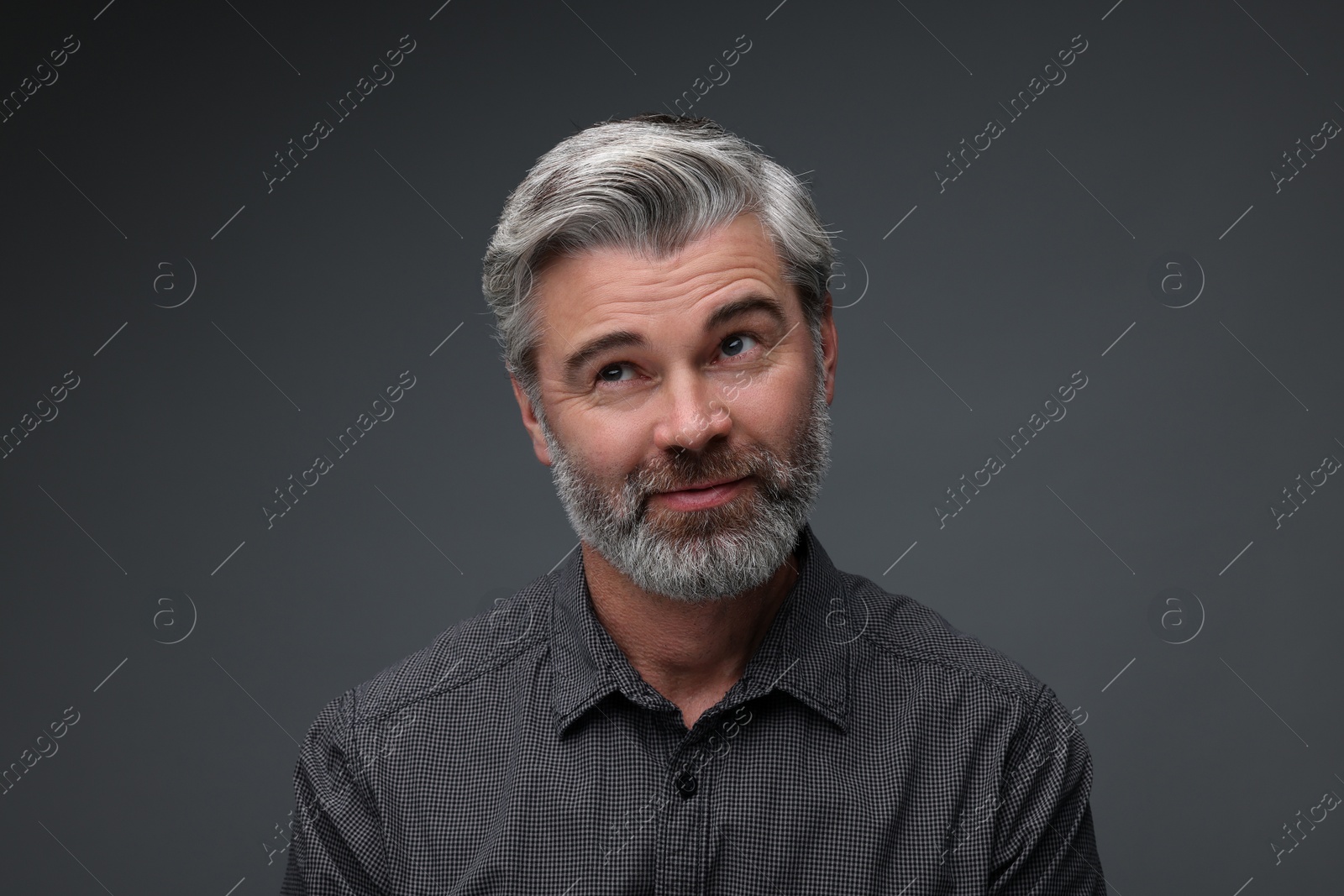 Photo of Personality concept. Portrait of bearded man on dark grey background