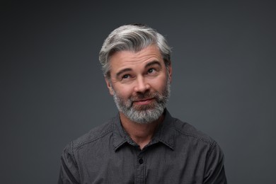 Personality concept. Portrait of bearded man on dark grey background