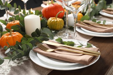 Photo of Beautiful autumn table setting. Plates, cutlery, glasses, pumpkins and floral decor