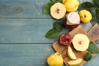 Photo of Delicious quince jam and fruits on light blue wooden table, flat lay. Space for text