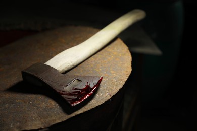 Photo of Axe with blood on rusty metal surface, closeup. Space for text