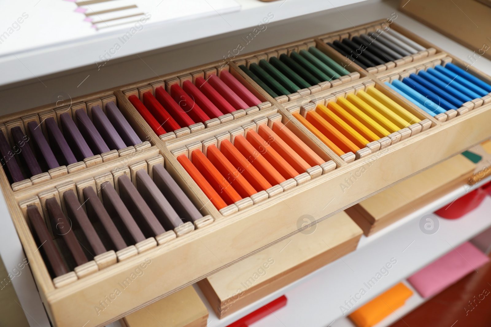 Photo of Wooden box with color tablets and other montessori toys on shelves