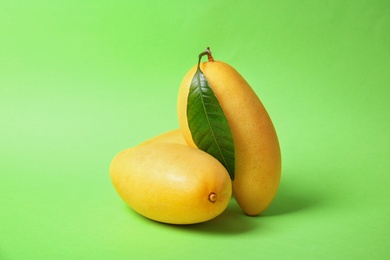 Photo of Fresh ripe juicy mango fruits on color background