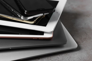 Photo of Many different modern gadgets on grey table, closeup