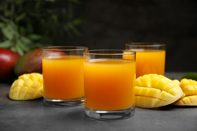 Photo of Fresh delicious mango drink on grey table