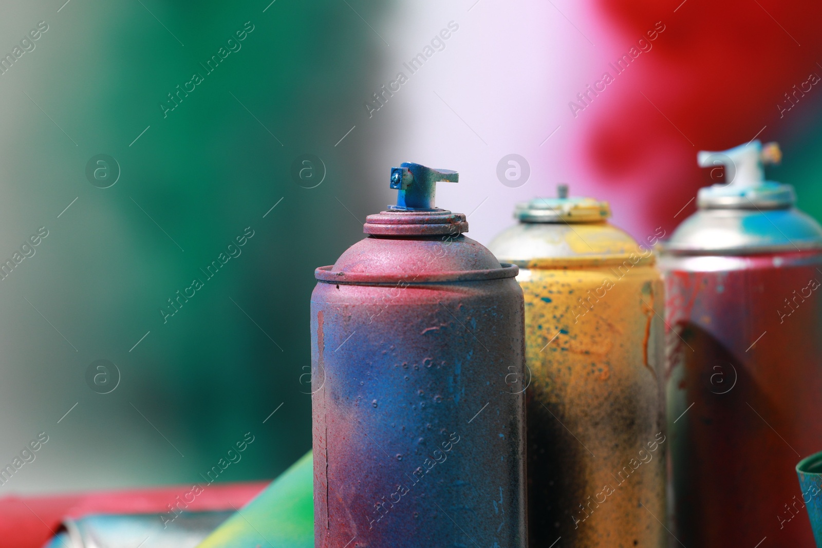 Photo of Many spray paint cans on color background, closeup. Space for text