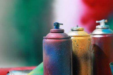 Many spray paint cans on color background, closeup. Space for text