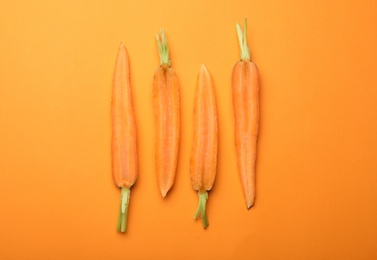 Photo of Flat lay composition with halves of fresh carrots on color background