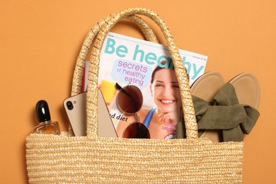 Photo of Flat lay composition with wicker bag and other beach accessories on orange background