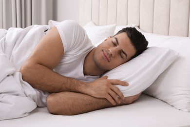 Handsome man sleeping in bed at home