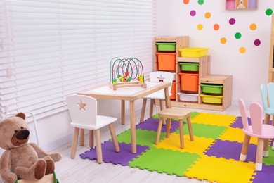 Photo of Stylish kindergarten interior with toys and modern furniture