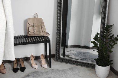 Modern hallway interior with large mirror and bench