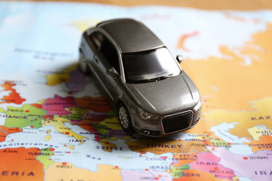 Photo of Grey toy car on world map. Trip planning